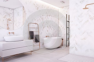 Chic bathroom featuring herringbone marble walls, freestanding tub, and gold accents. Modern luxury.