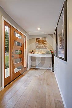 Chic foyer with a glass panel front door and white console table