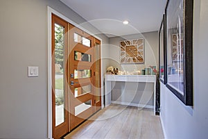 Chic foyer with a glass panel front door and white console table