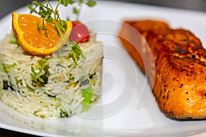 Chic plate of grilled salmon with broccoli rice garnished with fine herbs.