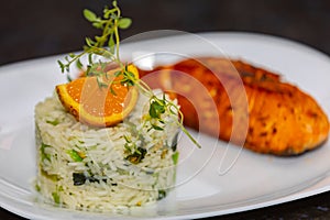 Chic plate of grilled salmon with broccoli rice garnished with fine herbs.