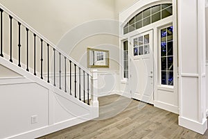 Chic white entryway design accented with high ceiling