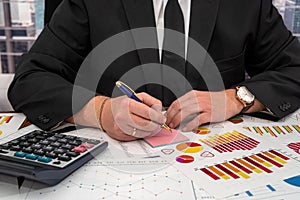 chic young male businessman calculates his business graphs at the office desk.