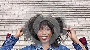 Chic Young Woman Playing with Her Afro in Urban Setting