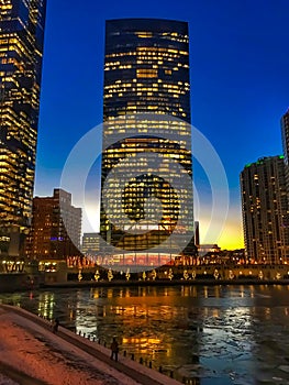 Chicago colorful city night lights illuminated and reflected onto a frozen Chicago River.