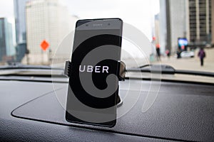 Chicago,IL,USA,Feb-21,2017,Smartphone attached to a car mount in car with Uber logo for editorial use only