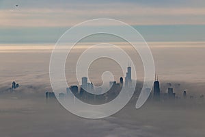 Chicago skyline popping up through clouds in the winter