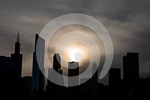 Chicago sunset silhoette skyline with airplane flying over modern buildings