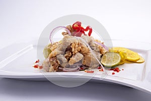 chicharon de pescado is ina peruvian food of fried marinated fish with onion aji and lemon.fried banana peruvian food