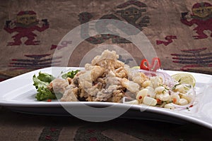 Chicharon de pescado is a Peruvian food of fried marinated fish with onion, aji and lemon. Peruvian food