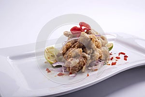 Chicharon de pescado is a Peruvian food of fried marinated fish with onion, aji and lemon. Peruvian food