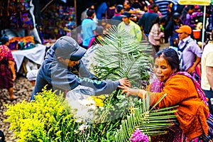 Chichicastenango, Guatemala on 2th May 2016: Indigneous woman with colorful clothes selling flowers on market in Chichicatenango