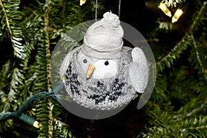 Chickadee holiday ornament in a knit sweater and jaunty cap.