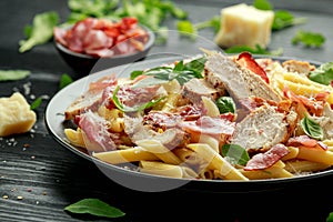 Chicken, bacon Penne pasta with parmesan cheese and basil. healthy food.