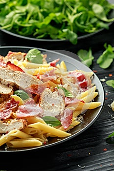 Chicken, bacon Penne pasta with parmesan cheese and basil. healthy food.