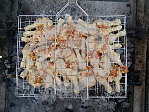 Chicken on BBQ with other ingredients.