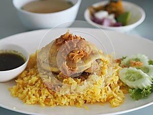 Chicken Biryani food, yellow color Traditional Indian dish of rice and chicken marinated in spices with green sauce