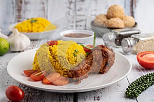 Chicken Biryani in a plate with spices on a white wooden floor