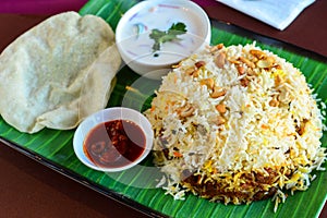 Chicken biryani thali served with curd and papad