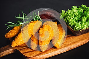 Chicken Breaded Raw Meat.Semifinished Breaded chicken nuggets from chicken fillet on a dark background with fresh herbs