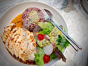 Chicken breast cooked topped chili with brown rice and vegetables in a white bowl