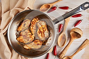 Chicken breast cooking in stainless steel pan