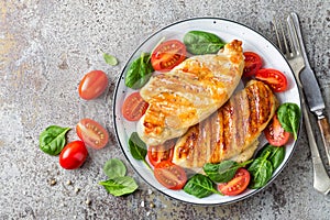 Chicken breast or fillet, poultry meat grilled and fresh vegetable salad of tomato and spinach