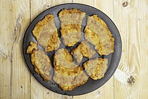 chicken breast fried with eggs on a black plate