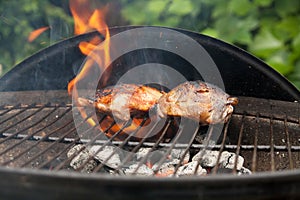 Chicken breast laying in the flames on barbecue