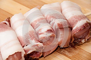 Chicken breast rolled in bacon on the wooden board