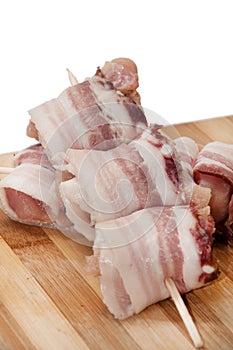 Chicken breast rolled in bacon on the wooden board