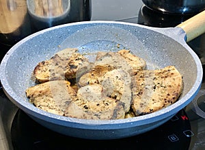 Chicken breast slices on a fry pan