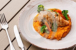 Chicken breast steak with carrot puree baby carrot and broccoli. Grilled chicken slice with baby carrot puree. wooden