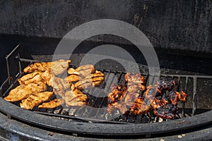 Chicken breasts and chicken wings are marinated and grilled on an outdoor grill