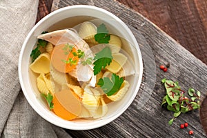 Chicken broth with pasta, carrots, parsley