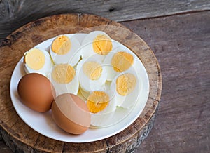 Chicken brown eggs, Sliced boiled eggs halves of peeled in white plate on wood table background