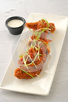 Chicken Buffalo Wings with dip served in a dish isolated on yellow background side view of fastfood