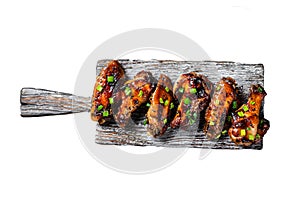Chicken buffalo wings in sweet and sour sauce with black sesame. Isolated, white background.