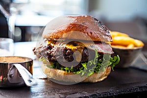 Chicken burger with avocado and 2 cheeses. Delicious healthy traditional food closeup served for lunch in modern gourmet