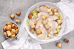 Chicken Caesar Salad in a Bowl with Parmesan Cheese, Dressing and Croutons