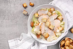 Chicken Caesar Salad in a Bowl with Parmesan Cheese, Dressing and Croutons