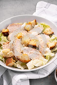 Chicken Caesar Salad in a Bowl with Parmesan Cheese, Dressing and Croutons