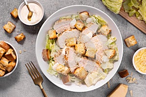 Chicken Caesar Salad in a Bowl with Parmesan Cheese, Dressing and Croutons