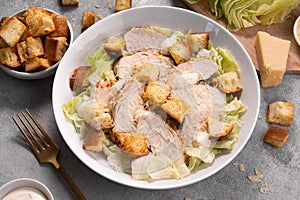 Chicken Caesar Salad in a Bowl with Parmesan Cheese, Dressing and Croutons