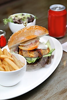 Chicken cajun burger with salad and soda