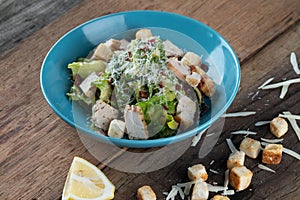 Chicken Cesar salad with croutons, grated cheese and lemon