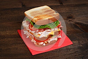 Chicken club sandwich on red napkin