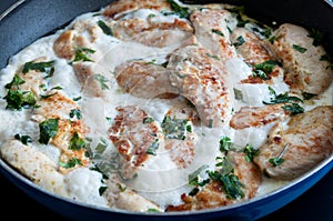 Chicken cooking in a cream sauce