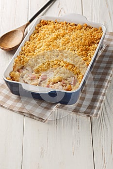 Chicken Cordon Bleu Casserole with chicken breast, cheese and ham melted in cream closeup in the baking dish. Vertical
