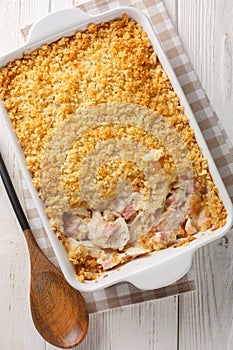 Chicken Cordon Bleu Casserole with chicken breast, cheese and ham melted in cream closeup in the baking dish. Vertical top view